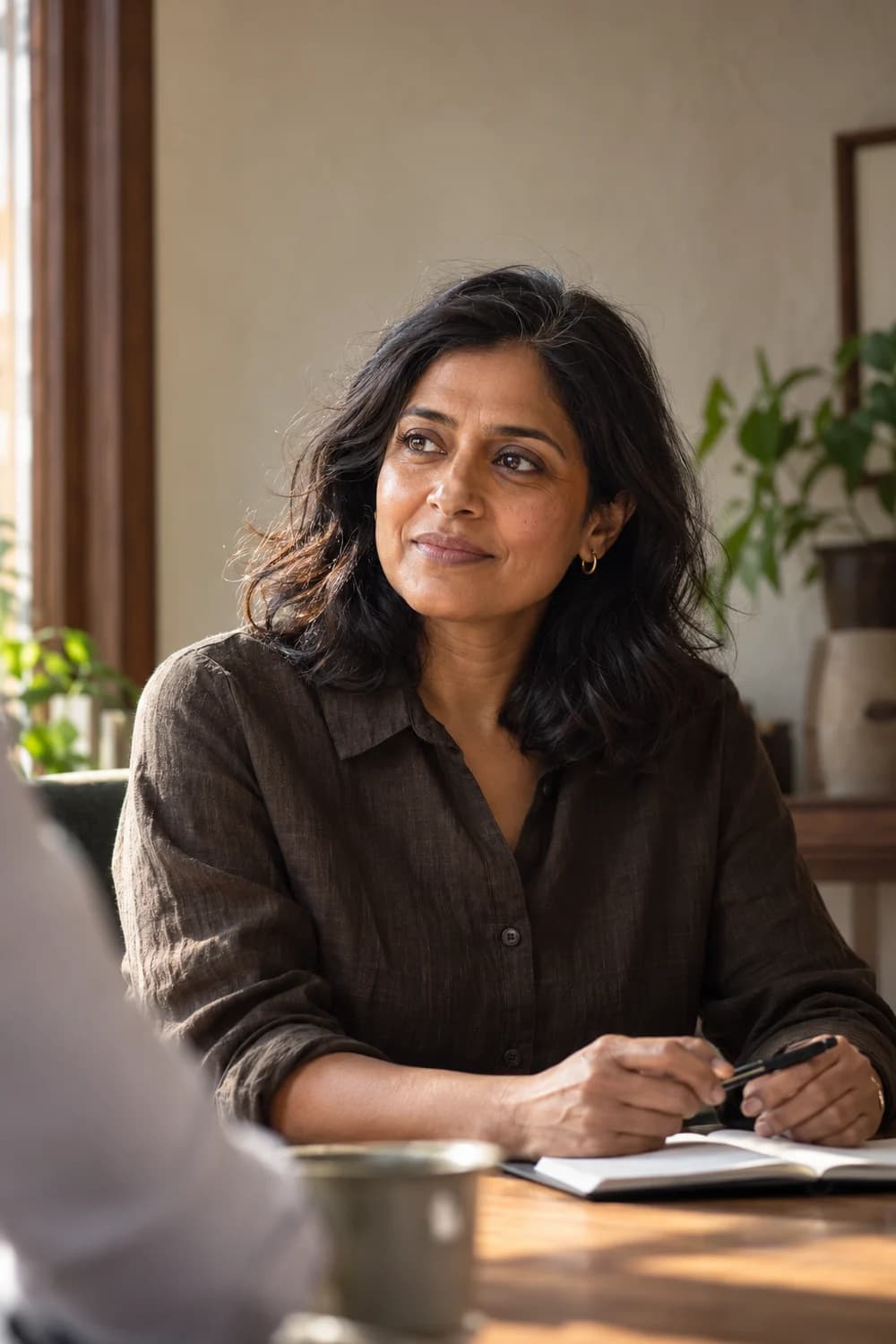A woman listening attentively during a conversation at a meeting table